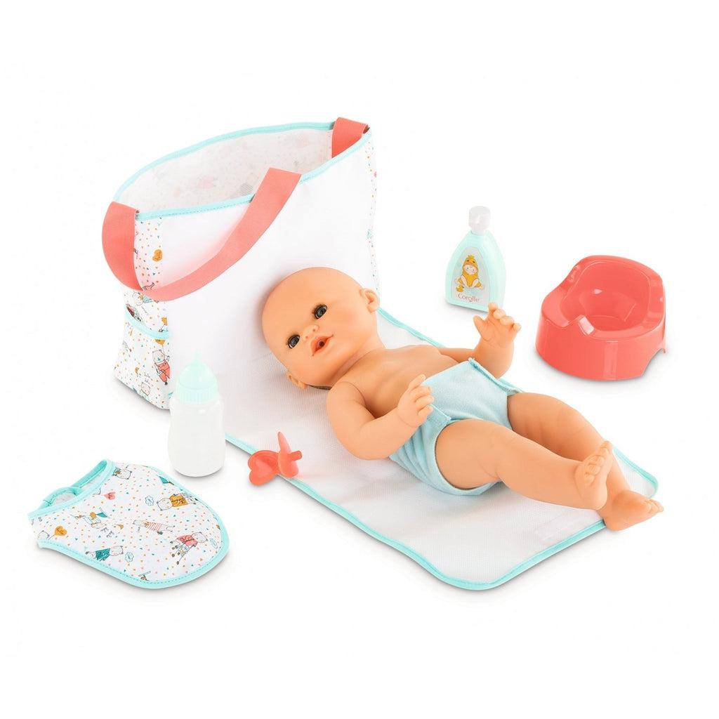 A baby doll is shown laying on the closure flap from the bag which doubles as a changing mat, the baby doll is also wearing the included blue cloth diaper.