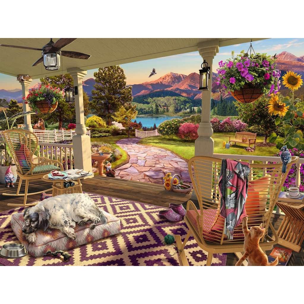Puzzle is a image of a front porch in early summer.There are many comfy chairs on the porch as well as a sleeping dog and playful cat. In the yard, there are many big trees, a bench, and in the background you can see tall mountains.