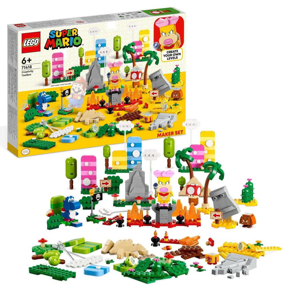 The lego set is shown in front of its box | There is a wendy the koopa figure standing on a tower and surrounded by a variety of lego super mario terrain and a blue yoshi
