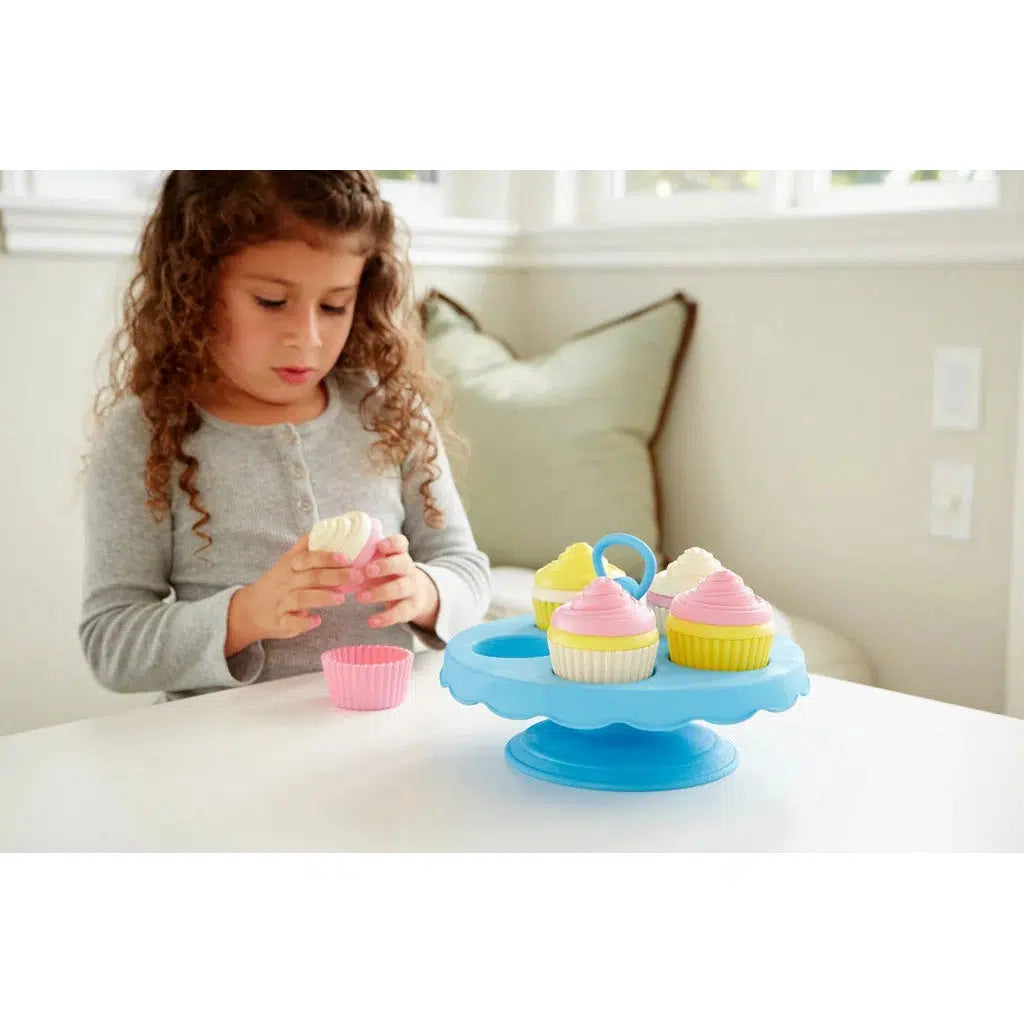 Scene of a little girl concentrating on making the best cupcakes possible.