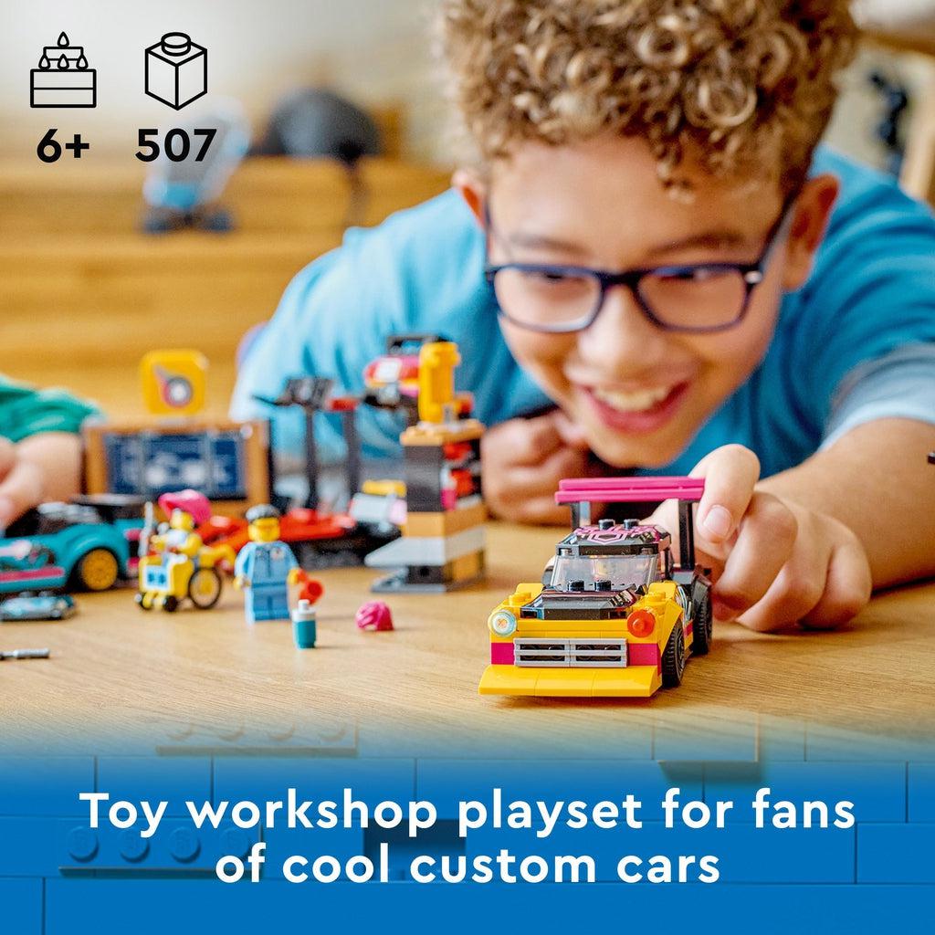 a child is shown playing with the lego set pushing along one of the lego cars | piece count of 507 and age of 6+ in top left | image reads: Toy workshop playset for fans of cool custom cars