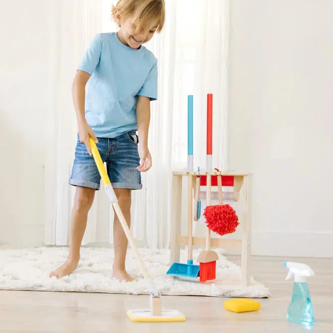 Scene of a little boy smiling while using the mop to clean the floors.