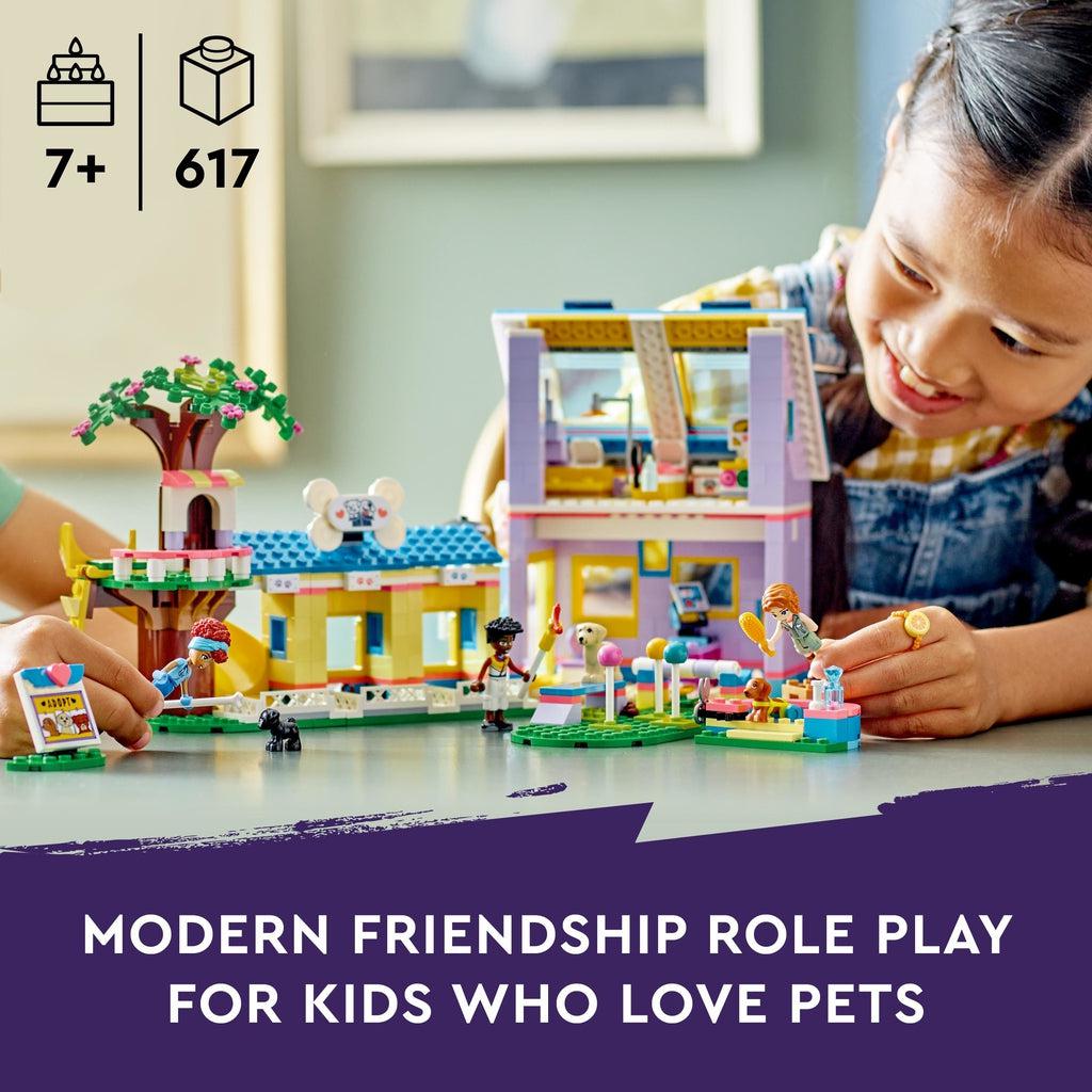 Image shows a girl and someone else's hands playing with the lego set | Image reads: Modern friendship role play for kids who love pets | Piece count of 617 and age recommendation of 7+ in top left.