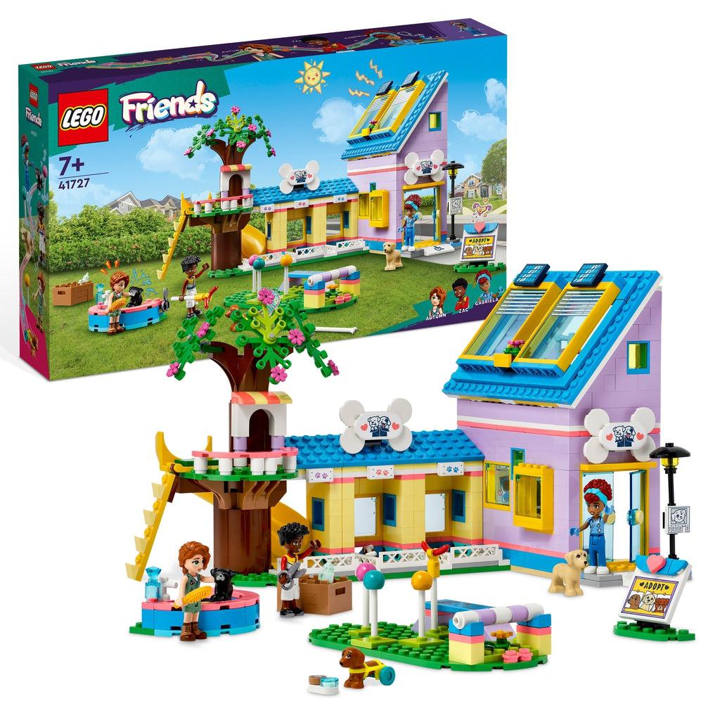 The playset is shown in front of the box. There is an L-shaped building with a treehouse attached to the end. There are dog training and grooming tools and stations in front of the building. 3 characters and 2 dog figures are shown