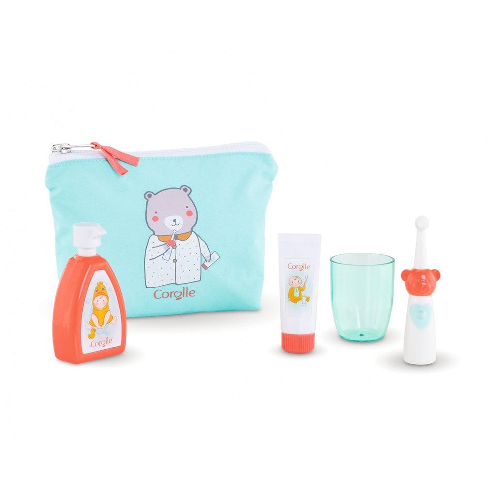 The care pouch and included items are displayed on a white background. There is a toothbrush with a bear head where the neck of the toothbrush meets the body, a green plastic cup, fake lotion and fake toothpaste. The bag displays a cartoon bear in pajamas holding toothpaste and toothbrush that are the same as the included accessories