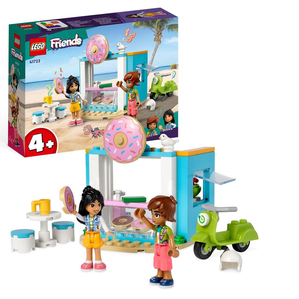 The playset is shown in front of the box, there are two lego friends characters in front of a mobile donut shop, a green motor scooter, and a small table.