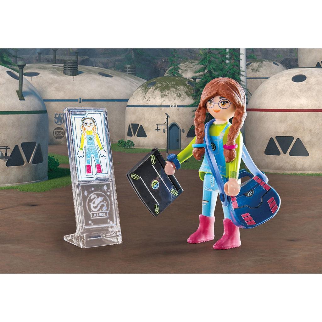 alex figure is displayed next to a childlike drawing of the character. the figure has brown braided pigtails, a green long-sleeved shirt under jean overalls, a blue satchel, and pink boots