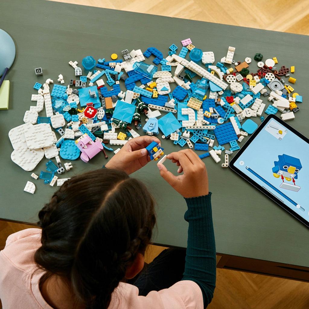 a girl uses the lego builder app for instructions on building this lego set