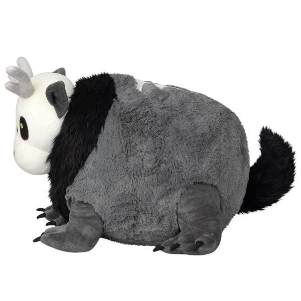 Side view of the plush. Shows that it has a large fluffy black tail in the back.