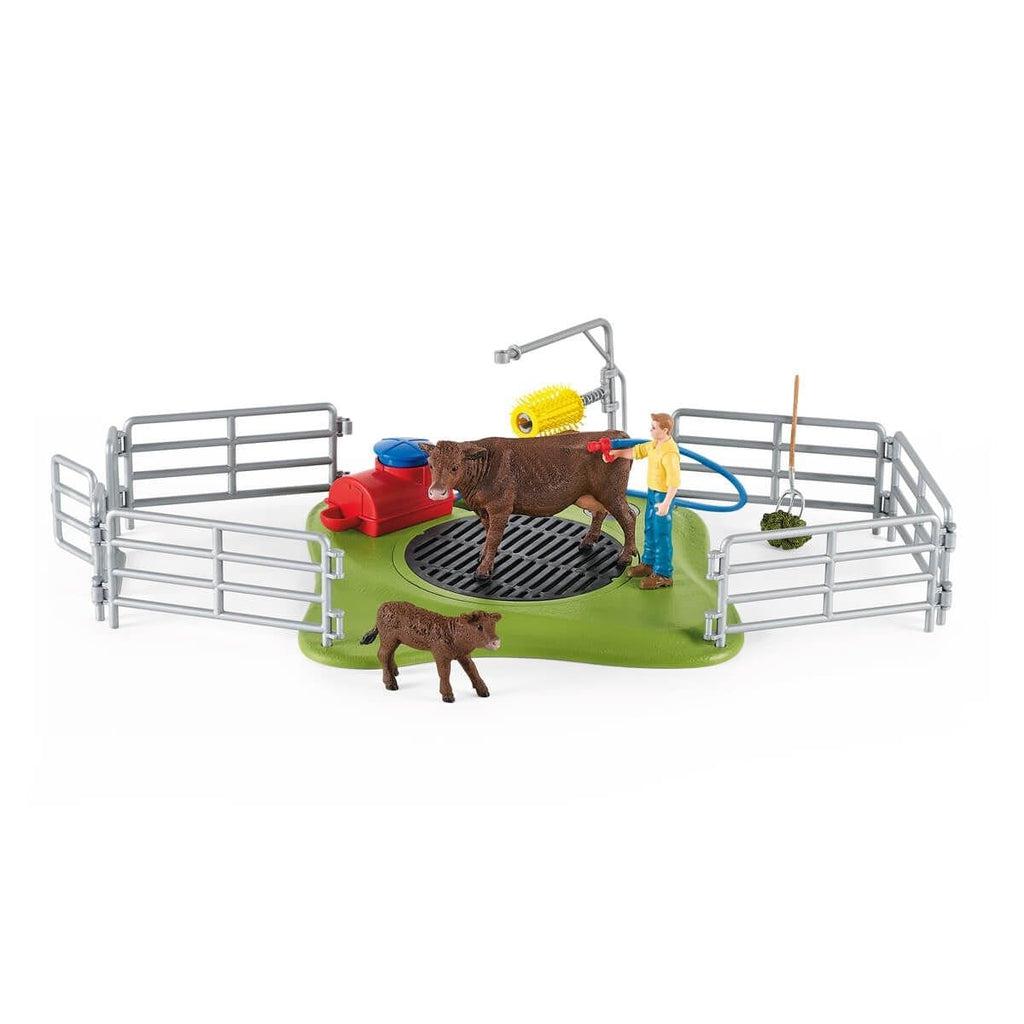 Image of all the included pieces outside of the packaging. The set includes a washing station, a mother cow, a baby cow, a rancher, and fences.