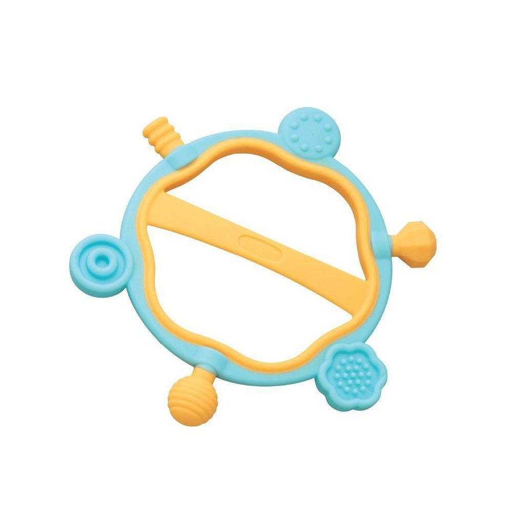 Image of the teething toy Hexy. It is a blue and orange ring with a hexagonal pattern on the inside. At each hexagonal point, there is a different shape and texture.