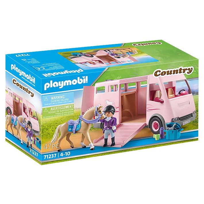 front of the box shows the playmobil rider figure standing next to the saddled horse on the ramp into the large pink transport van