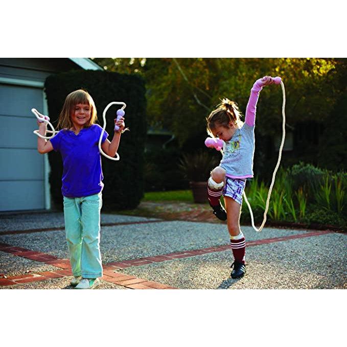 two girls are seen outside playing with the jump ropes