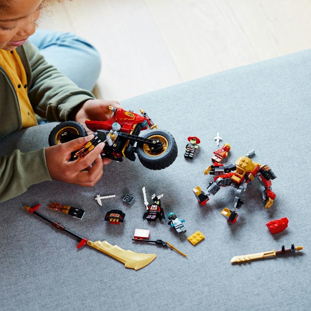 A child is shown putting the last few pieces o the nearly finished bike, with all the other parts to the set completed and spread on the table.