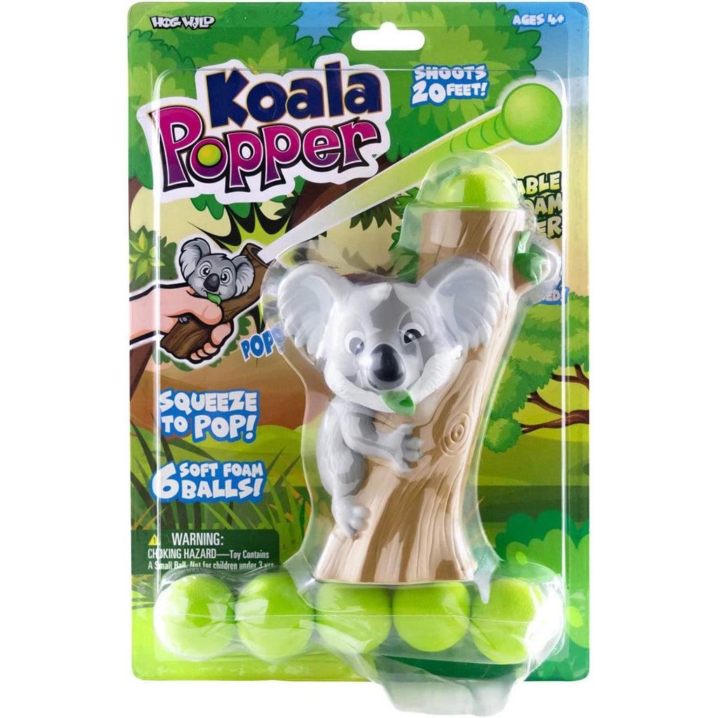 The koala popper is packaged in cardboard backed plastic. Text reads. Koala Popper, shoots 20 feet, squeeze to pop, 6 soft foam balls.