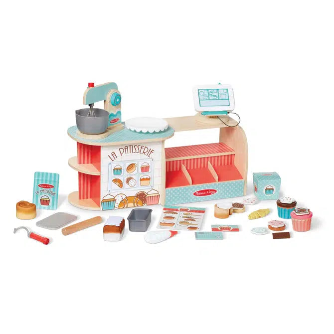 Image of the put together bake shop outside of the packaging. It is mainly red and light blue colored. It has many different parts included such as a register tablet, a standing mixer, various baking tools and pastries. 