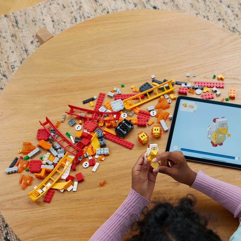 a girl is using the lego builder app for instructions on how to build the lego set