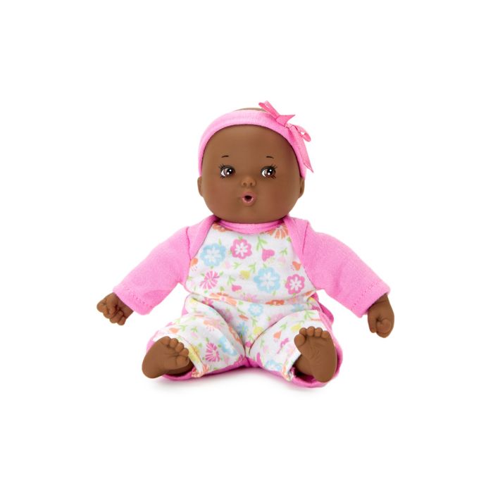 Doll with a dark skin tone. | Doll is wearing a pink bow and pink onesie with a flower printed white front panel.