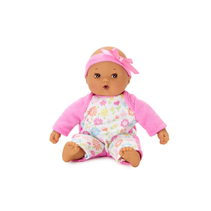 Doll with medium skin tone. | Doll is wearing a pink bow and pink onesie with a flower printed white front panel.