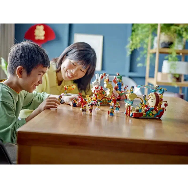 A child and his mother are shown playing with the lego set on a table