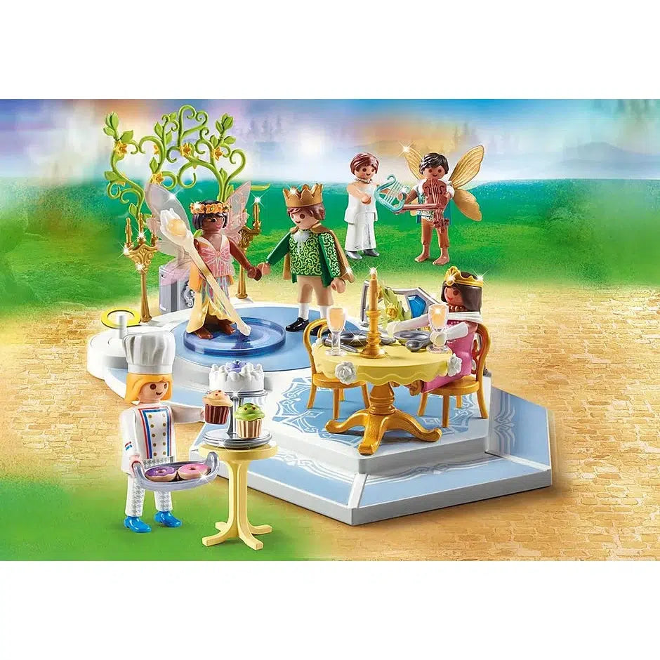 the dance is shown, there is a dance floor for two playmobil figures, a food table and a baked goods table, and 6 playmobil figures, two of which are fairies