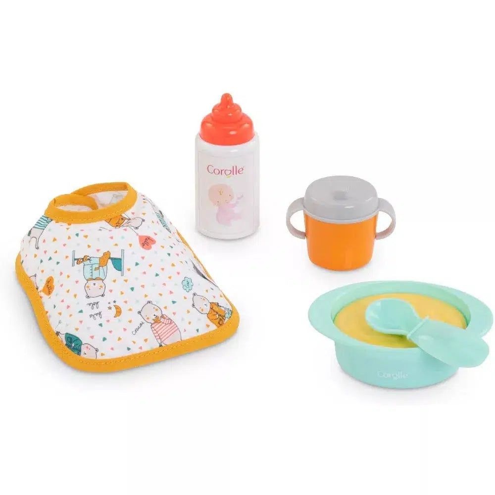The set includes a bib with bear characters printed on it, an orange sippy cup a bottle, and a bowl and spoon. All doll sized.