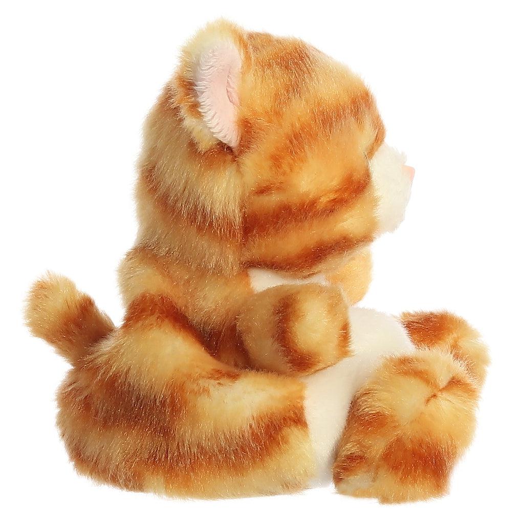 Side view of the cat plush. From this view you can see that she has a small tube-shaped tail in the back.