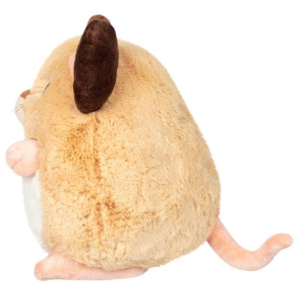 Side view of the plush. Shows that it has a long curvy tail sticking out of the back.
