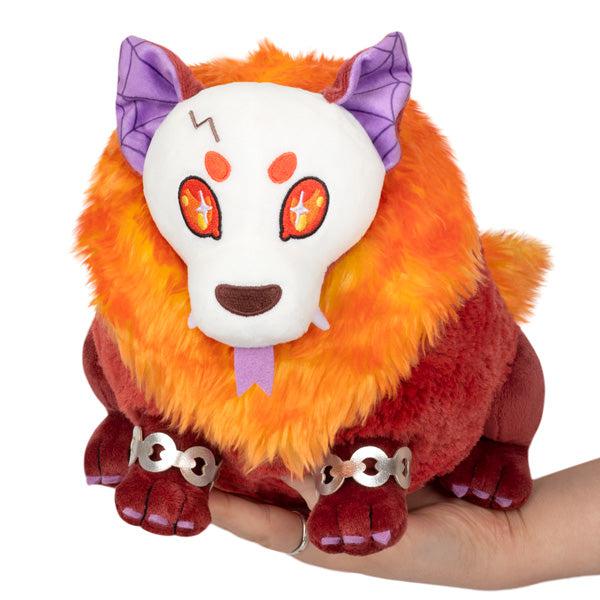 Image of the Mini Hellhound squishable. It is a red undead dog with an orange mane and purple ears.