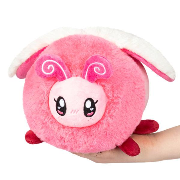 Image of the Mini Lovebug squishable. It is a pink bug with white wings and dark pink feet.