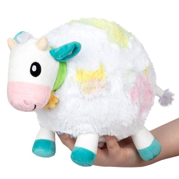Image of the Mini Tie Dye Cow squishable. It is a white cow with different tie dye pastel spots all over. 