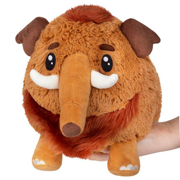 Image of the Mini Wooly Mammoth squishable. It is sienna colored plush with a darker red hair tuft on the top of its head and a matching beard.