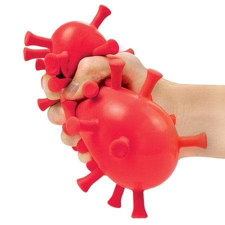 A red frazzle ball is being squeezed by a hand. The ball is covered in long knobby protrusions to give added variety in stress relief.