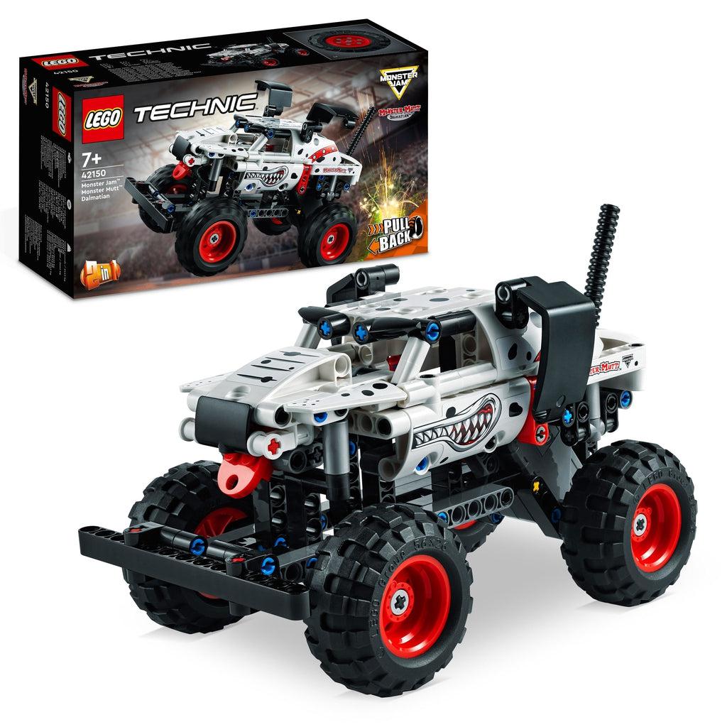 The lego monster truck is shown in front of its box | The truck gives the impression of a dalmatian with pieces like ears to the side, blue cross shaped pieces in black tubes for eyes, and a red rounded tag like piece like a tongue below the bumper