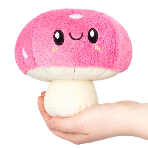 Image of the Mushroom Snacker squishable. It is a happy pink mushroom plush.