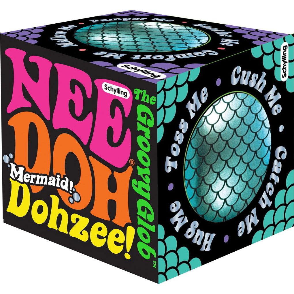 The front of the box Reads NeeDoh Mermaid! Dohzee! The groovy glob, with the schylling logo in the top right, the main text is written in a 70's retro style. The right and top of the box feature a cutout showing the needoh inside and it's mermaid print. Around the holes into the box is the text; Toss me, cush me, catch me, hug me.