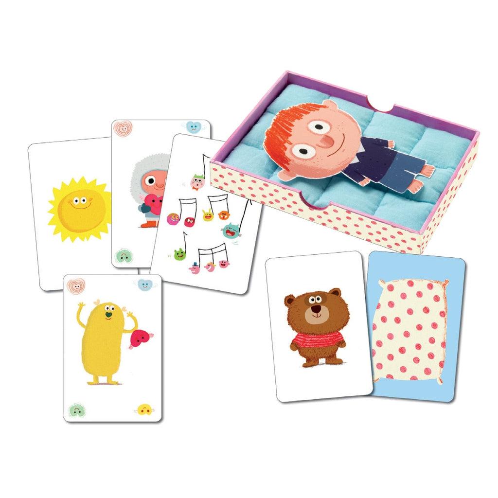 Image of the included parts to the game. Comes with cards showing different drawings such as a sun, a bear, music notes, etc., a mattress, and a reversible little boy/little girl character.