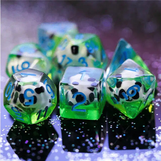 The D8, D6, and D12 are shown with the rest out of focus behind. Each dice is made of clear resin with a little panda inside and green resin mixed in below the pandas for a grassy look..