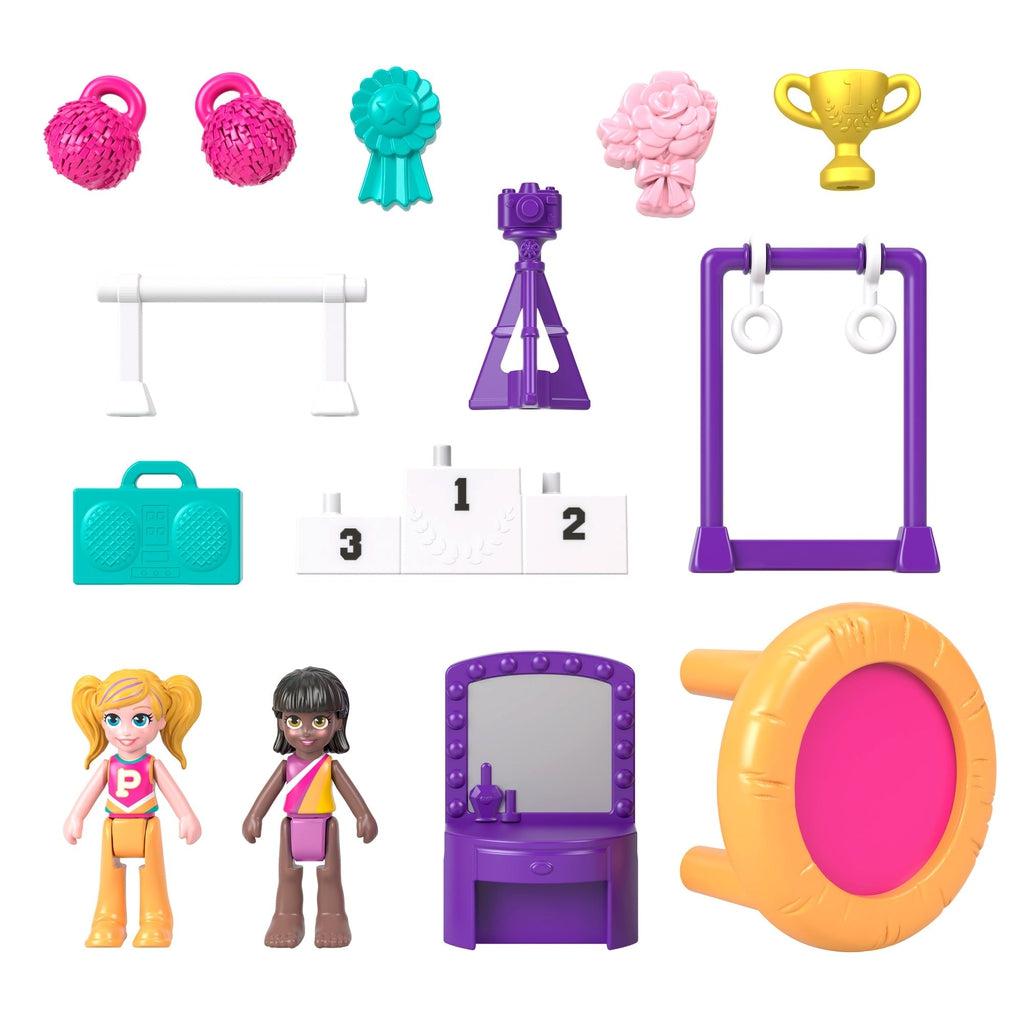 Image of the included pieces. The set comes with two Polly Pocket Dolls, a mirror, a trampoline, a boom box, ribbons and trophies, and gymnastics bars.
