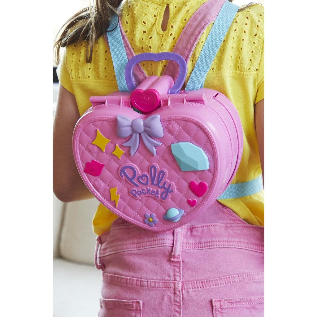 Close-up of young girl wearing theme park backpack using shoulder straps.