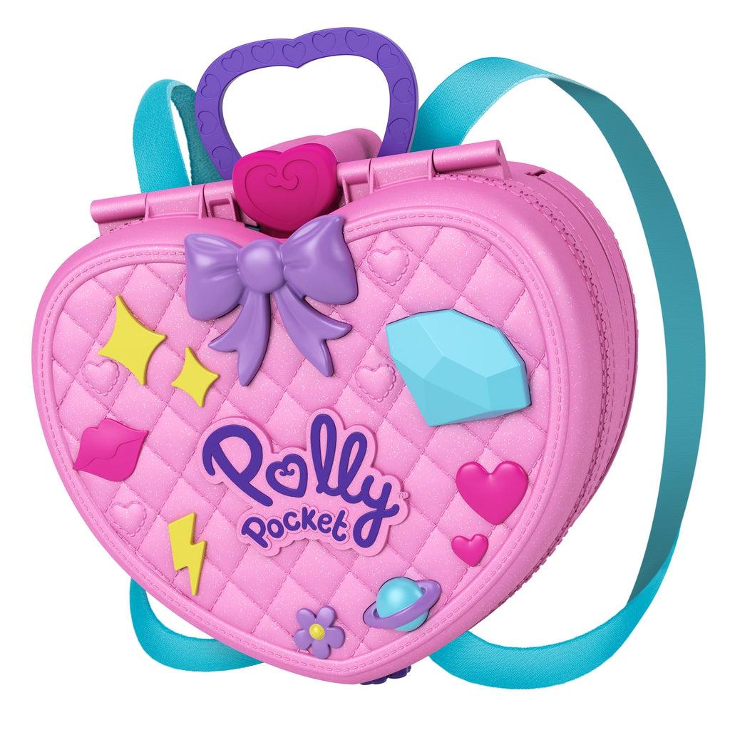 Backpack out of packaging | Backpack is a large quilted pink heart with Polly Pocket logo, purple bow, and details shaped like lips, a diamond, a planet, hearts, flower, and star shapes. | Carrying handle at the top of the backpack is made of purple plastic with heart idents.