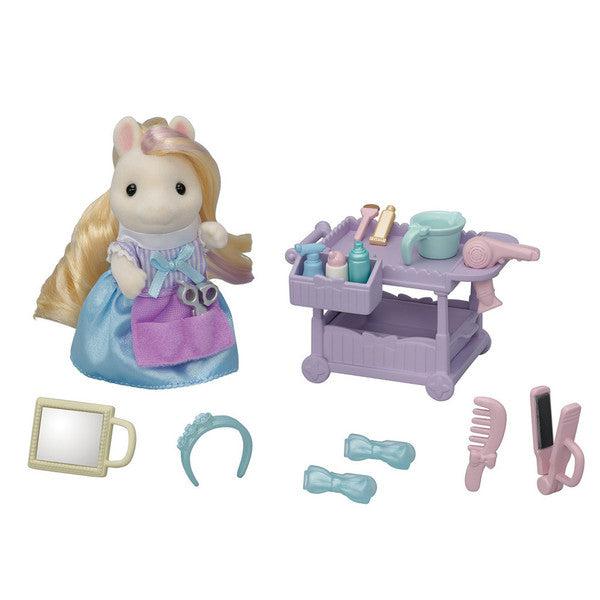 Image of all the pieces outside of the packaging. It includes a pony stylist doll, a hair stylist cart, and an assortment of styling tools such as combs, straighteners, hair dryers, and a hand mirror.