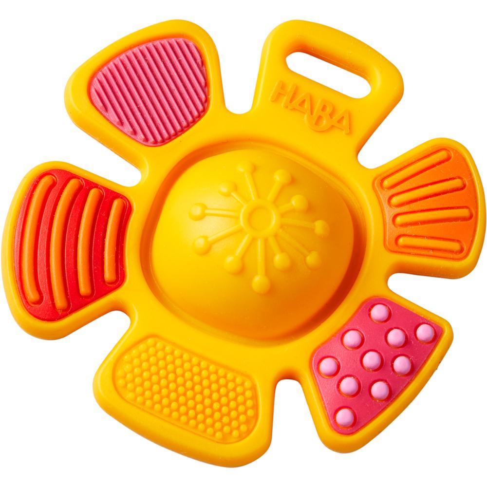 Image of the teething toy outside of the packaging. It is in the shape of an orange flower. Each petal has a different texture in a red, orange, and yellow color scheme. The center of the flower is a puffy rubber bulb.