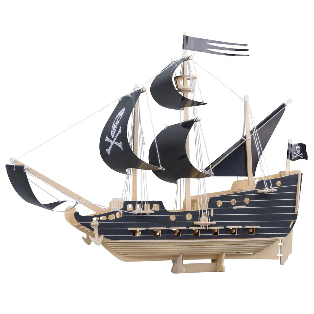 Image of the fully built ship. It is made from wood, string, and plastic coated fabric. Most of it is a natural wood color, but some parts are painted black. On one of the sails is a symbol of a skull and cross bones.