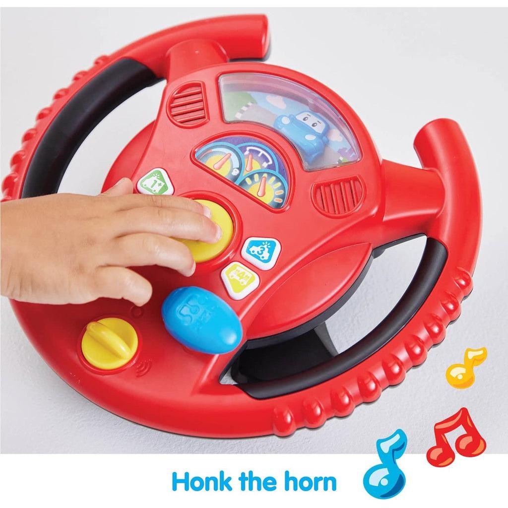 Shows the little kid honking the horn in the center of the steering wheel.