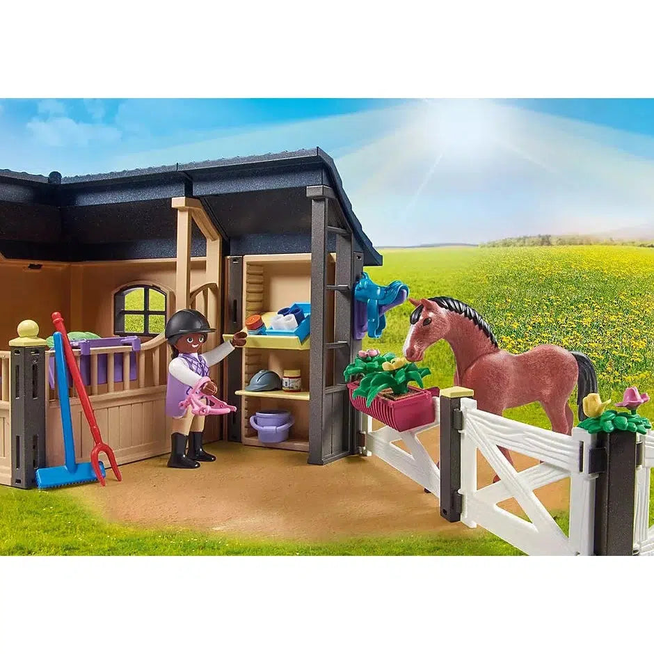 adult figure gathers supplies from the stable shelves while the horse looks at her over the paddock fence