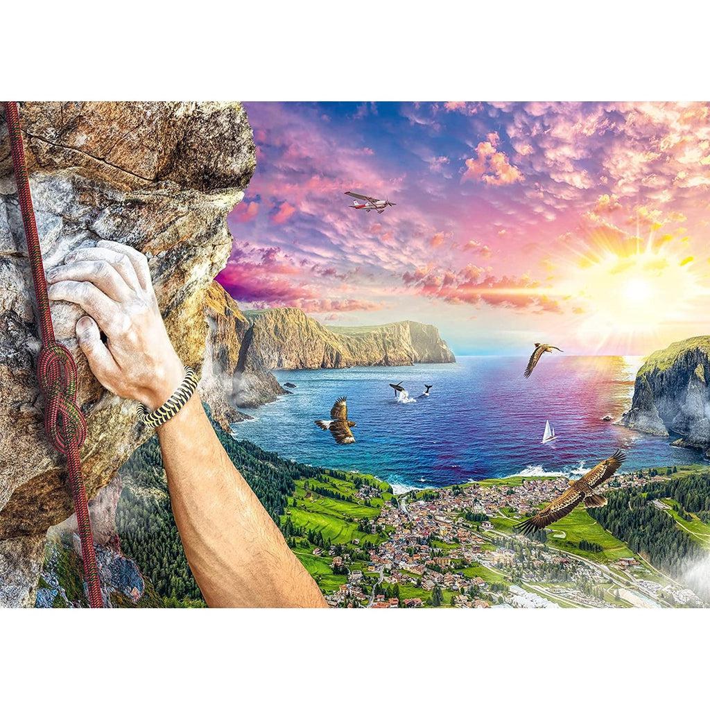Puzzle is of a rock climber over looking a town on the coast of the ocean. You can tell that the climber is high up because there are eagles circling next to you. There is a beautiful sunset turning the clouds all sorts of pretty colors.