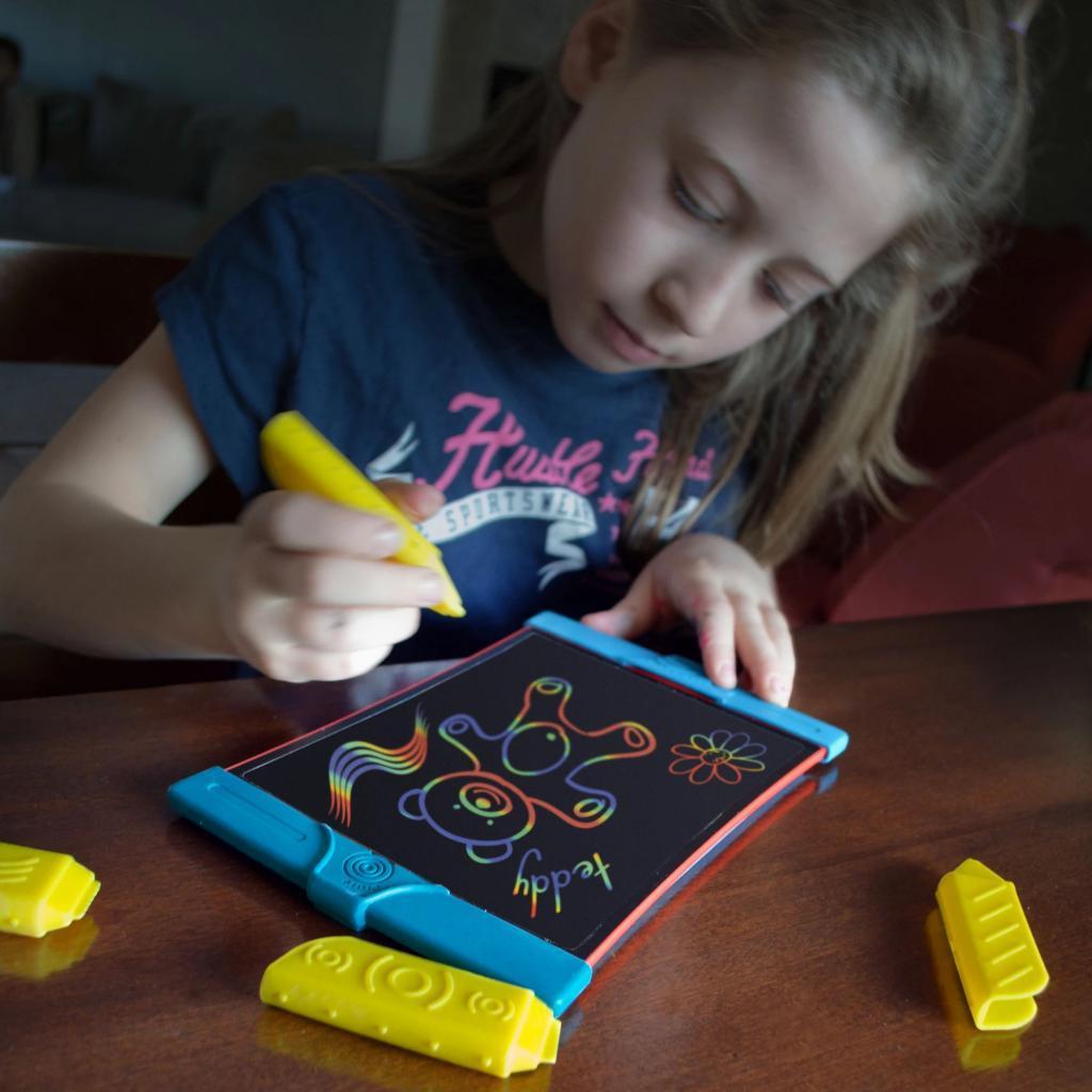 a child is drawing a teddy bear in rainbow colors on the boogie board