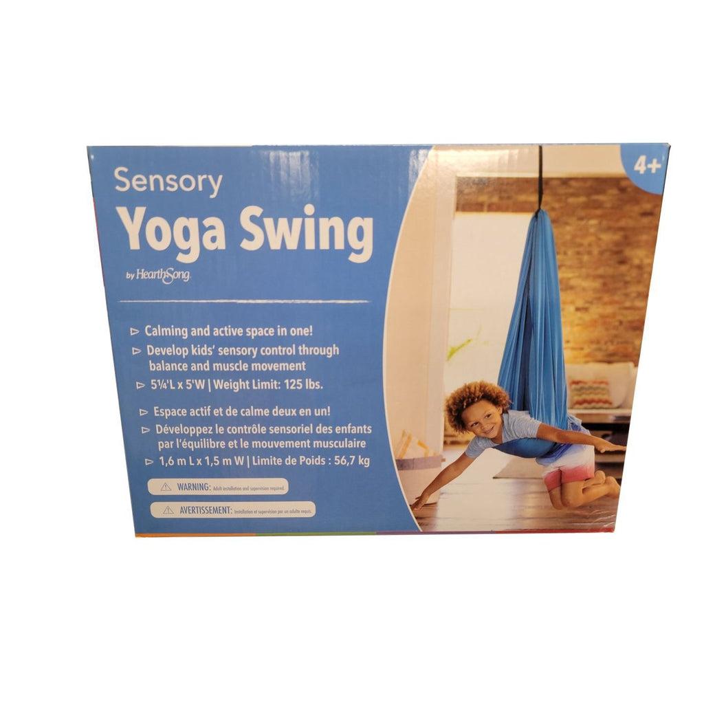 Sensory Yoga Swing Box from HearthSong. 4+ is listed in the top right corner above a picture of a child swinging on their stomach using the product. Text on the box reads: Calming and active space in one! Develop kids' sensory control through balance and muscle movement. 5 1/4'L X 5'W | Weight limit: 125 lbs. The bottom left of the box contains a warning that adult supervision is required.