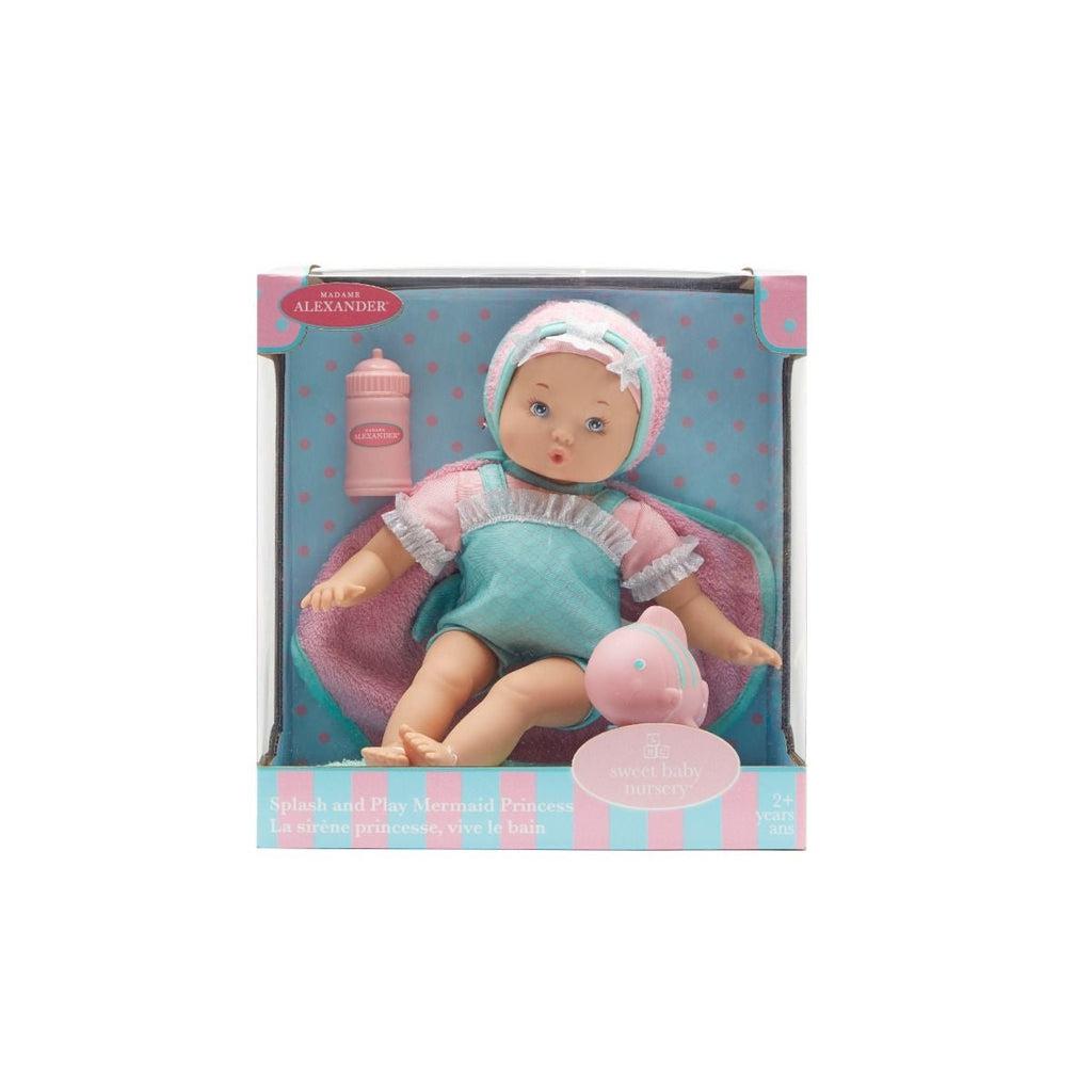 Doll in packaging | Packaging is blue and pink striped with a blue and pink polka dot background behind the doll.